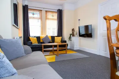 a living room with a couch and a table at Newly Launched 3 Bedroom House with Free Parking in Litherland