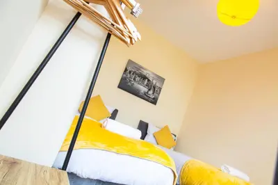 a bedroom with a bed with yellow sheets at Newly Launched 3 Bedroom House with Free Parking in Litherland