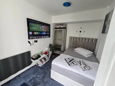 a bedroom with a bed and a flat screen tv at Ensuite room with private entrance and private garden in Blackpool