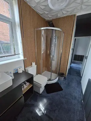 a bathroom with a shower and a toilet and a sink at Ensuite room with private entrance and private garden in Blackpool