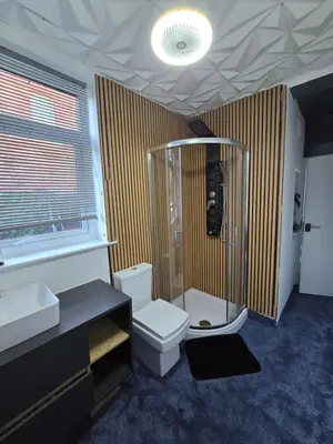 a bathroom with a shower and a toilet and sink at Ensuite room with private entrance and private garden in Blackpool