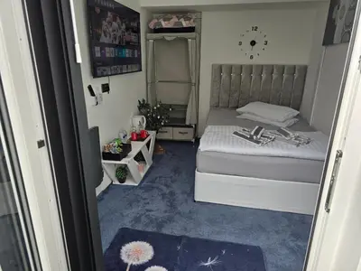 a small bedroom with a bed and blue carpet at Ensuite room with private entrance and private garden in Blackpool