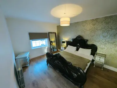 a bedroom with a large bed with a black bed frame at Richmond Apartment in Liverpool