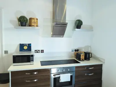 a kitchen with a stove and a microwave at Richmond Apartment in Liverpool