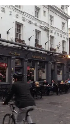 a man riding a bike in front of a restaurant at Richmond Apartment in Liverpool