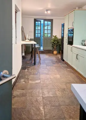 a kitchen with a tile floor and a table at Historic 17th-Century Cottage with Hot Tub in Charming Heysham in Heysham