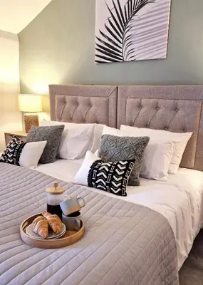 a bed with a tray of pastries on it at Historic 17th-Century Cottage with Hot Tub in Charming Heysham in Heysham