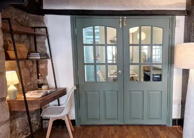 a green door in a room with a desk at Historic 17th-Century Cottage with Hot Tub in Charming Heysham in Heysham