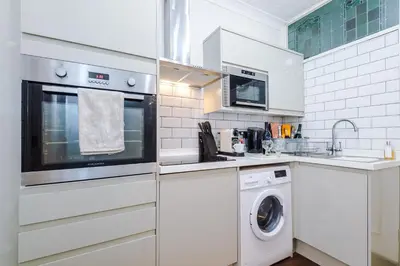 a white kitchen with a washer and dryer at Stylish 1-Bed Apartment in St. Annes in Lytham St Annes