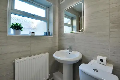 a bathroom with a sink and a toilet and a mirror at Stay With Alexandra 2 Free Parking - high speed Free Wifi close to stadiums in Liverpool
