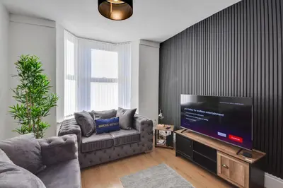 a living room with a couch and a flat screen tv at Stay With Alexandra 2 Free Parking - high speed Free Wifi close to stadiums in Liverpool