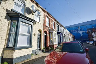 a red car parked in front of a brick building at Stay With Alexandra 2 Free Parking - high speed Free Wifi close to stadiums in Liverpool