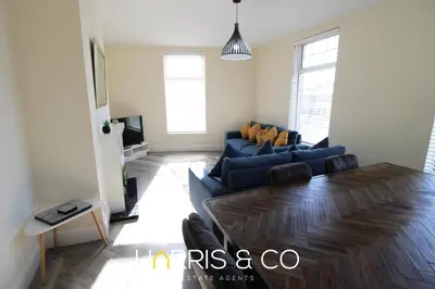 a living room with a blue couch and a table at Light House View in Fleetwood