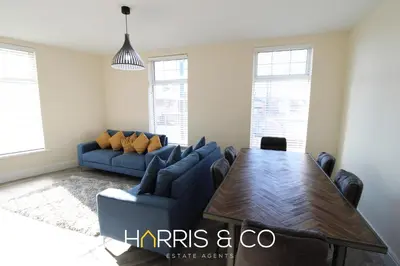 a living room with a blue couch and a table at Light House View in Fleetwood
