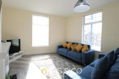 a living room with a blue couch and a tv at Light House View in Fleetwood