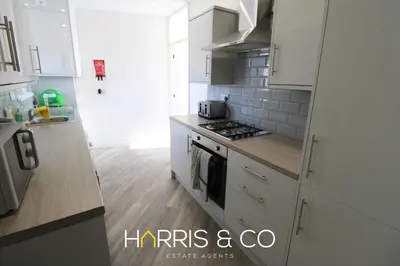 a kitchen with white cabinets and a stove top oven at Light House View in Fleetwood