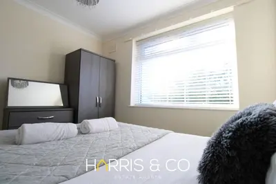 a bedroom with a bed and a dresser and a window at Poolfoot Villas in Thornton