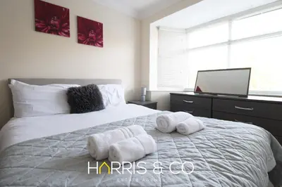 a bedroom with a white bed with towels on it at Poolfoot Villas in Thornton
