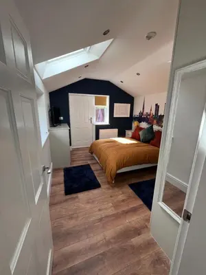 a bedroom with a bed and blue rugs at Waterside Cottage in Preston