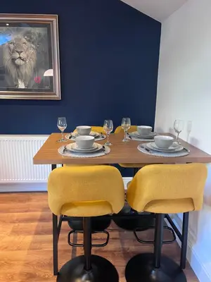 a dining room with a wooden table with yellow chairs at Waterside Cottage in Preston
