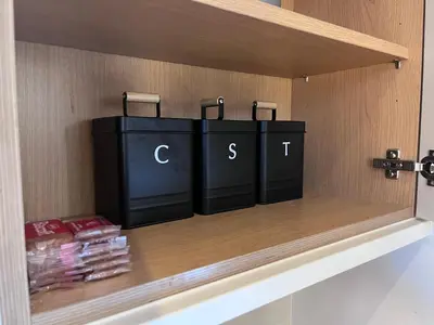 a shelf with three black containers on it at Waterside Cottage in Preston