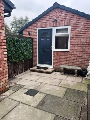 a brick house with a blue door and a window at Waterside Cottage in Preston