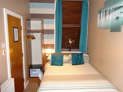 a bedroom with a bed with two blue pillows at The Craimar in Blackpool