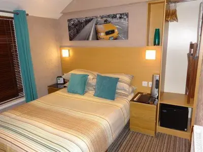 a hotel room with a bed and a car on the wall at The Craimar in Blackpool