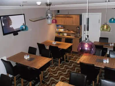 a restaurant with wooden tables and chairs and a tv at The Craimar in Blackpool