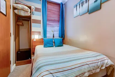 a bedroom with a bed with blue pillows and a window at The Craimar in Blackpool