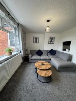 a living room with a couch and a table at Zetland House Apartment - First floor with garden and parking in Southport