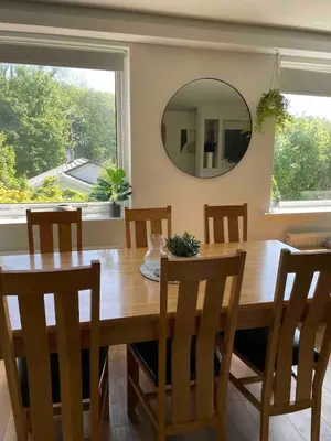 a dining room table with chairs and a mirror at Holiday Bungalow in Arnside in Arnside
