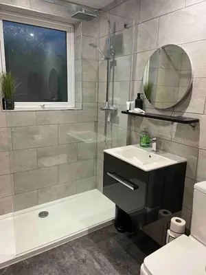 a bathroom with a sink and a shower and a mirror at Holiday Bungalow in Arnside in Arnside
