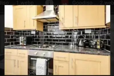 a kitchen with wooden cabinets and a stove top oven at Providence Luxury Apartment in Liverpool