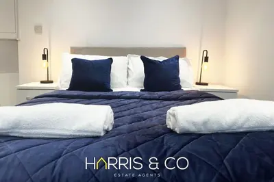 a large bed with blue and white sheets and pillows at Kittiwake in Fleetwood