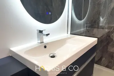 a white sink in a bathroom with a mirror at Kittiwake in Fleetwood