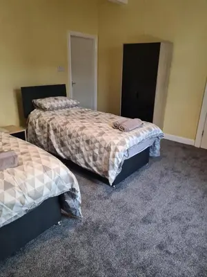 two beds sitting in a room with carpet at The Eagle and Child in Garstang