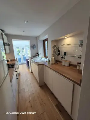 a kitchen with white cabinets and a wooden floor at Shore Cottage A traditional cosy cottage in Wilpshire
