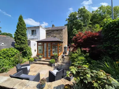 a house with a garden with chairs in front of it at Shore Cottage A traditional cosy cottage in Wilpshire