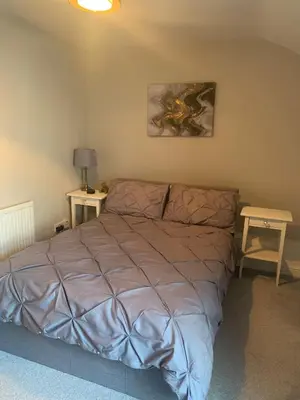 a bedroom with a bed and a table with a lamp at Shore Cottage A traditional cosy cottage in Wilpshire