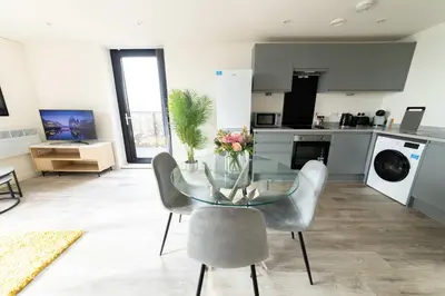 a dining room with a glass table and chairs in a kitchen at Spacious 1 Bedroom Apartment in Central Liverpool in Liverpool