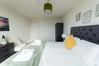 a bedroom with a large white bed and a couch at Spacious 1 Bedroom Apartment in Central Liverpool in Liverpool