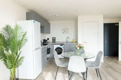 a kitchen with a glass table and white appliances at Spacious 1 Bedroom Apartment in Central Liverpool in Liverpool