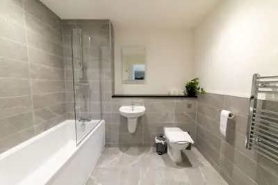 a bathroom with a sink and a toilet and a bath tub at Spacious 1 Bedroom Apartment in Central Liverpool in Liverpool