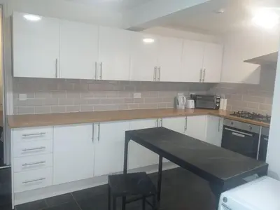 a kitchen with white cabinets and a table in it at Liverpool 3-Bed House - Sleeps 6 in Liverpool