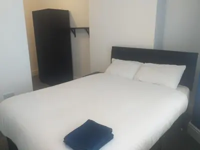 a large white bed with a blue pillow on it at Liverpool 3-Bed House - Sleeps 6 in Liverpool