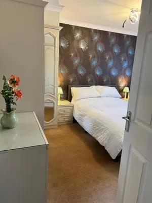 a bedroom with a white bed and a mirror at Linden Ave Bungalow in Thornton