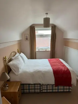 a bedroom with a large bed with a window at Linden Ave Bungalow in Thornton