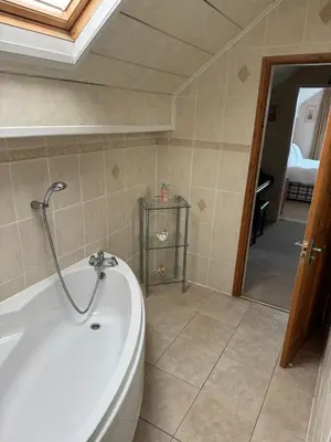 a bathroom with a bath tub in a room at Linden Ave Bungalow in Thornton