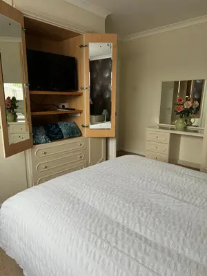 a bedroom with a large bed and a television at Linden Ave Bungalow in Thornton